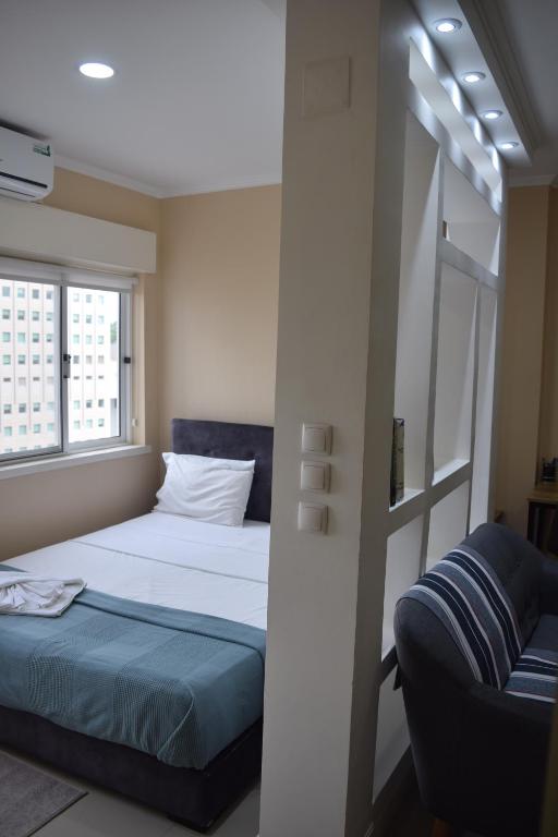 - une petite chambre avec un lit et un canapé dans l'établissement Cozy Studio, à Luanda