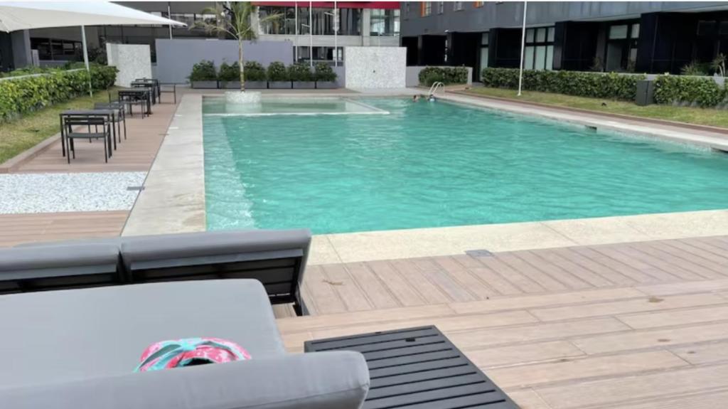 - une piscine avec des tables et des chaises dans un bâtiment dans l'établissement Amplio Departamento 2 Recamaras, à Mexico