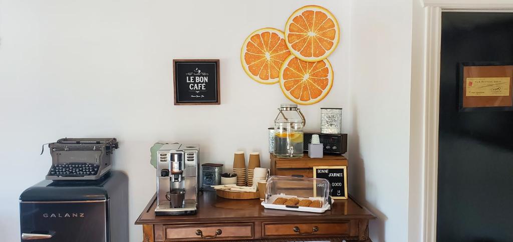 a kitchen with a counter with a coffee maker and oranges on the wall at Motel Gentilhommière in Saint-Siméon