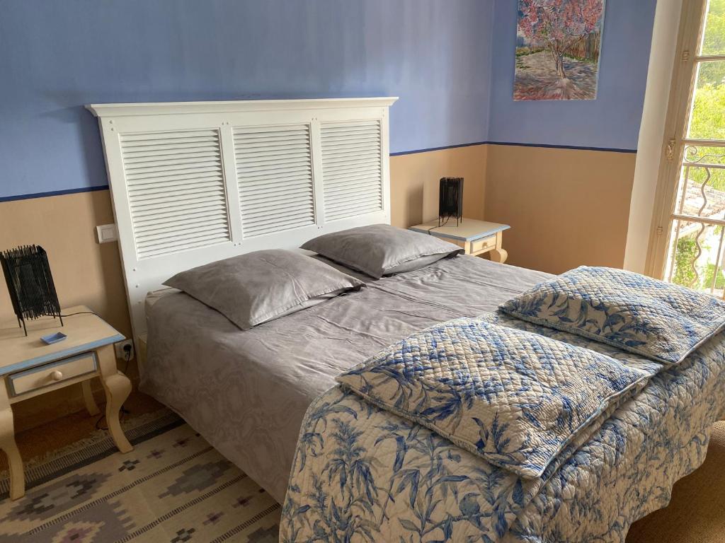 a bedroom with a bed and two tables and a window at Mas des IRIS in Saint-Rémy-de-Provence