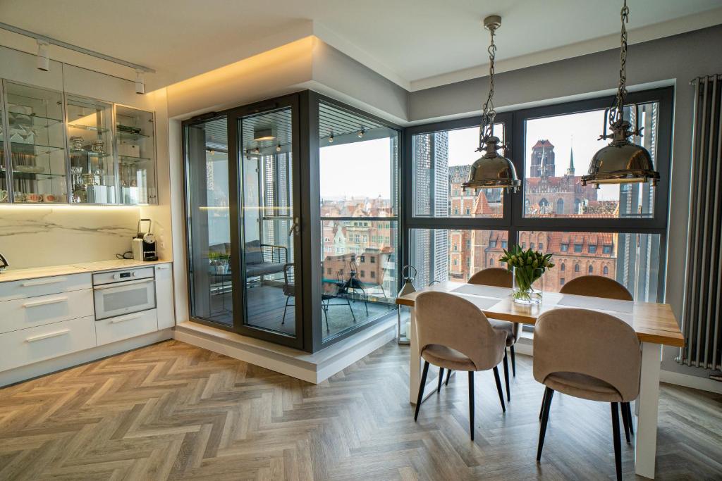 a kitchen and dining room with a table and chairs at My River Side in Gdańsk