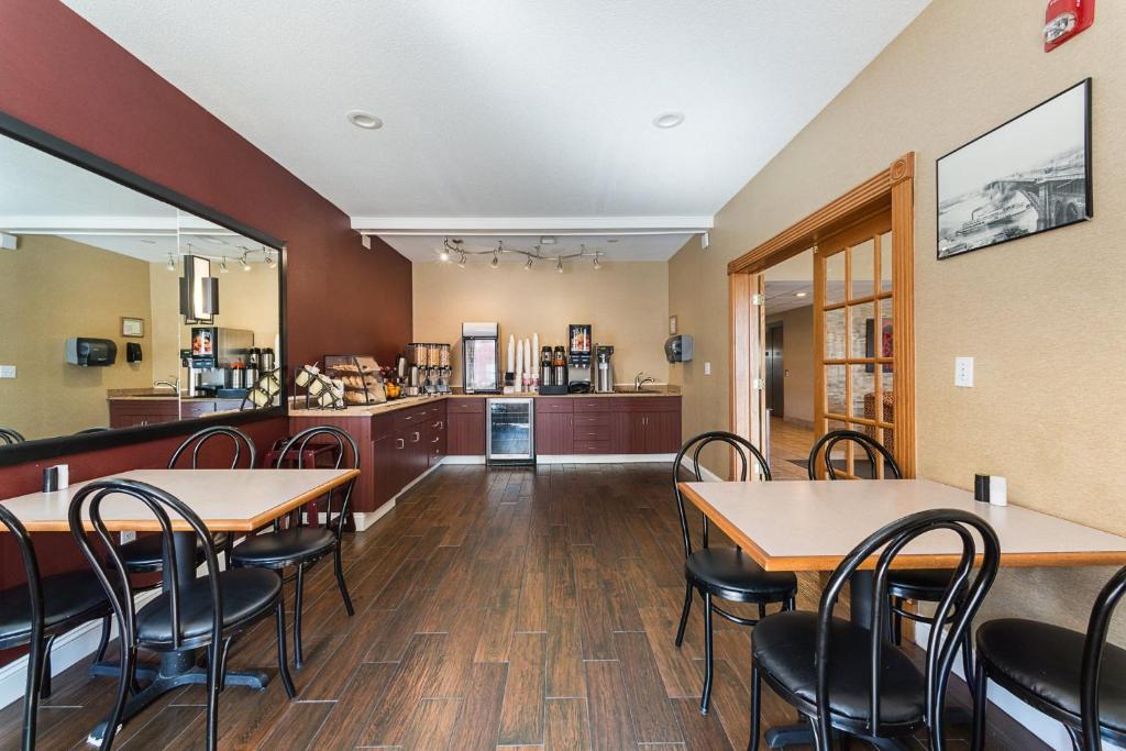 a dining room with tables and chairs and a kitchen at Red Roof Inn St Louis - Troy, IL in Troy