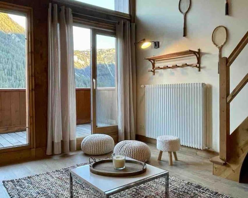 a living room with a table and two chairs at Courchevel 1650 appartement cosy 6 personnes in Courchevel