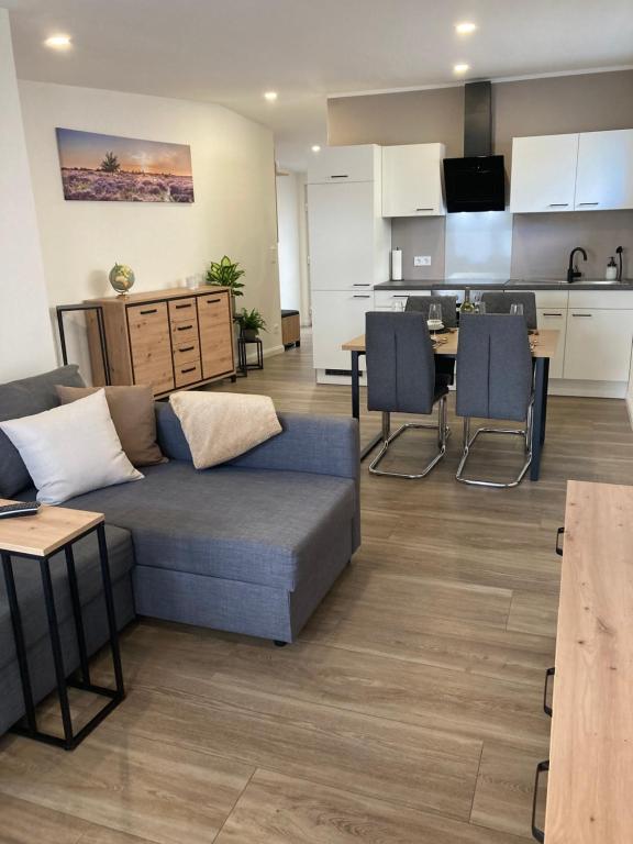 a living room with a couch and a kitchen at Moderne Ferienwohnung mit Balkon in Herxheim