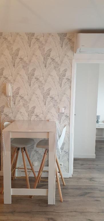 a table and stool in a room with a wall at Appartement Ajaccio vue mer panoramique in Ajaccio