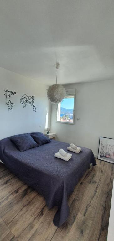 a bedroom with a bed with two towels on it at Appartement Ajaccio vue mer panoramique in Ajaccio