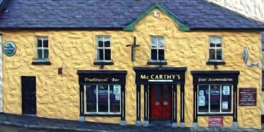 un grande edificio giallo con una porta rossa di McCarthy's Westport a Knockhill and Drinagh