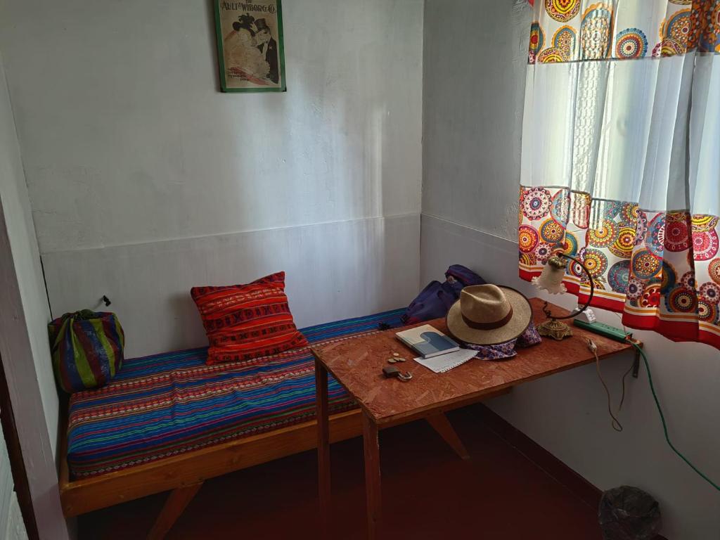 una habitación con un banco con un sombrero en una mesa en Viajeros en Salta