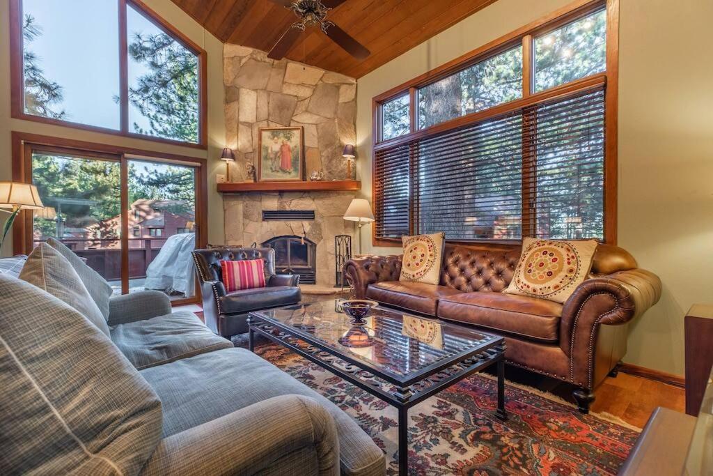 a living room with leather couches and a stone fireplace at Townhouse Art Gallery in Mammoth's Best Location in Mammoth Lakes