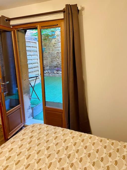 sypialnia z łóżkiem i dużym oknem w obiekcie Appartement au cœur du centre historique w mieście Bergerac