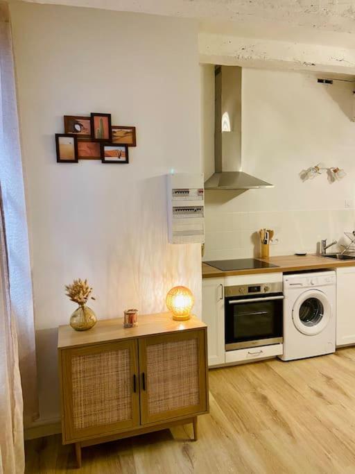kuchnia z kuchenką i kuchenką mikrofalową w obiekcie Appartement au cœur du centre historique w mieście Bergerac