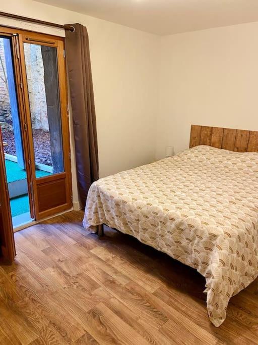 sypialnia z łóżkiem i dużym oknem w obiekcie Appartement au cœur du centre historique w mieście Bergerac