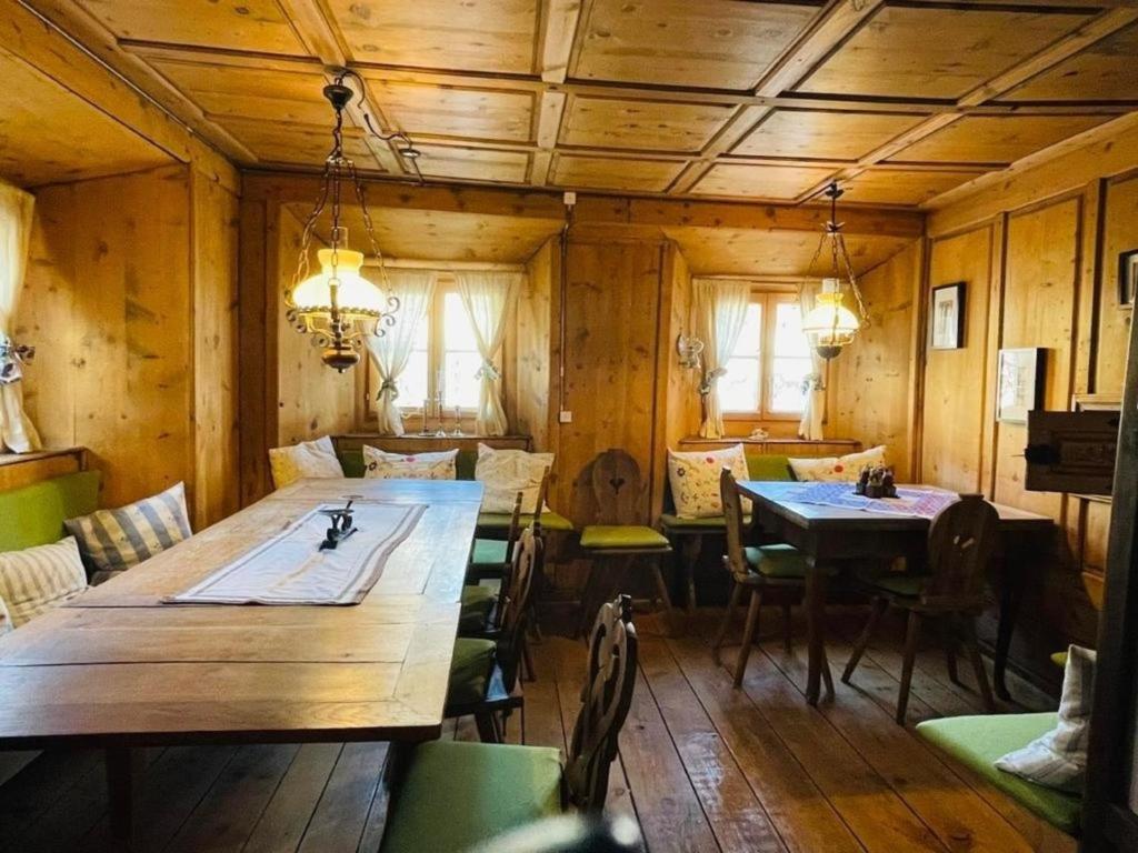 una sala da pranzo con un grande tavolo in legno e sedie di Chasa Gertz 12-Bett Chasa Engiadina a Sent