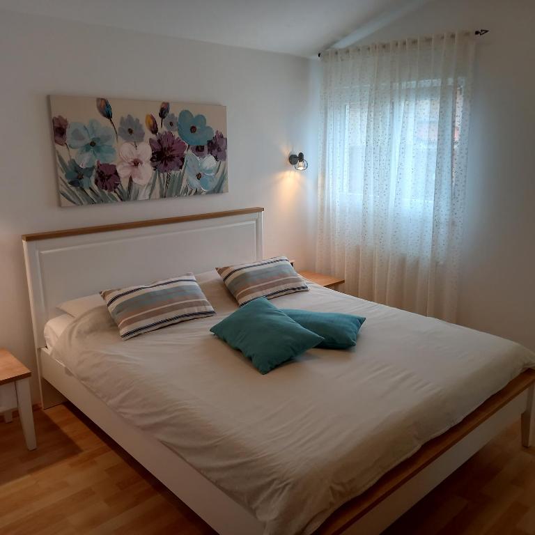 łóżko z dwiema poduszkami w sypialni w obiekcie Apartments Irena with sea view w Fažanie