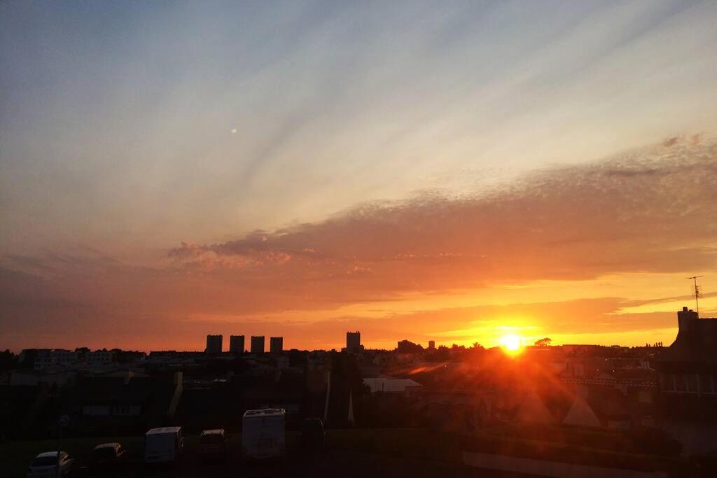 una puesta de sol sobre una ciudad con la puesta de sol en Cozy'Maisonnette, en Guipavas