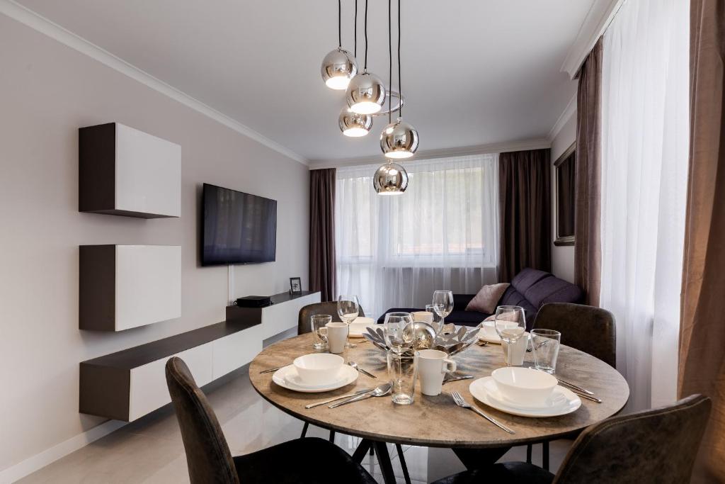 a dining room with a table and a living room at ApartamentyGdansk eu Mieszkanie Przylesie in Sopot