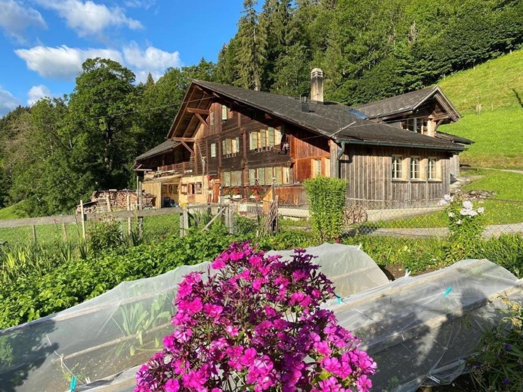 a house with a garden with flowers in front of it at Ferienhaus Schönenmatte in Zweisimmen