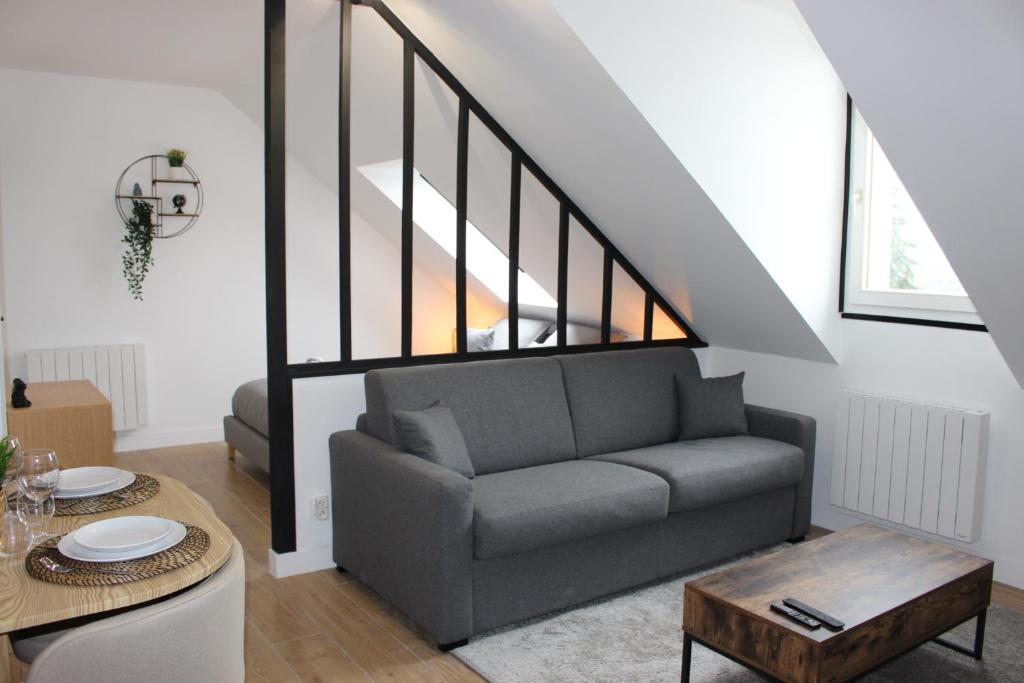 a living room with a couch and a table at Appartement Cosy - Disney Paris in Chalifert