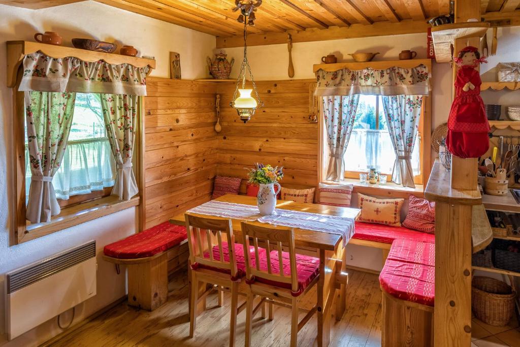 Chalupa pod lipou في أوسكادنيكا: غرفة طعام مع طاولة وكراسي في كابينة