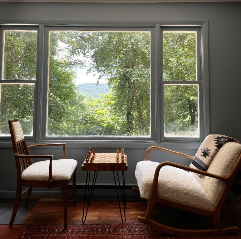 een kamer met 2 stoelen, een tafel en ramen bij The perfect getaway cabin in Washington