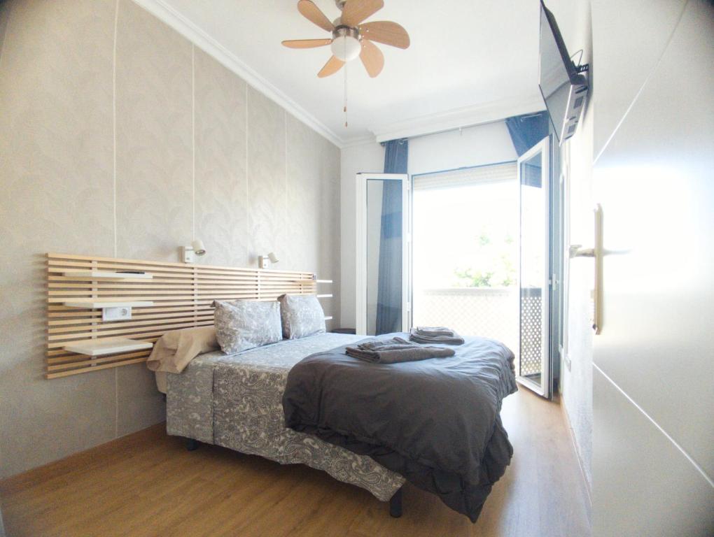 - une chambre avec un lit et un ventilateur de plafond dans l'établissement Apartamento Hermosilla, à Malaga