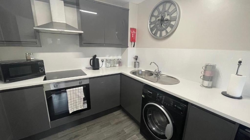 a kitchen with a washing machine and a sink at Hosted By Ryan - 1 Bedroom Apartment in Liverpool