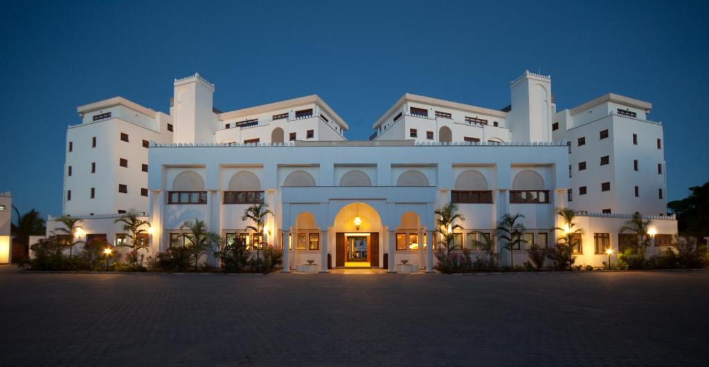 a large white building at night with its lights on at Lantana Galu Beach in Diani Beach