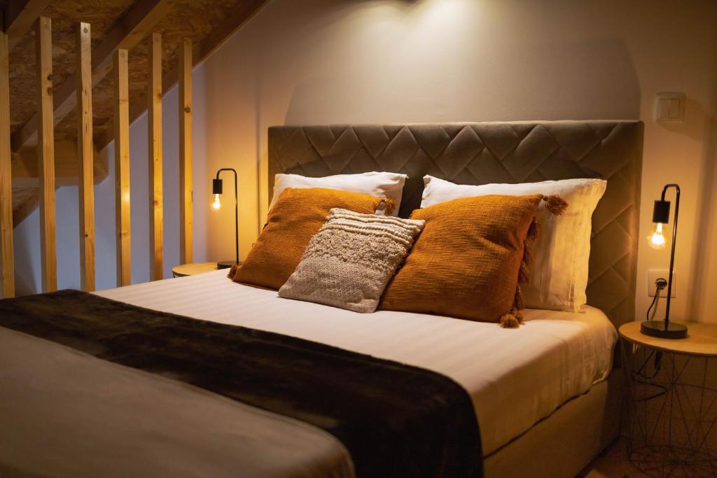 a bedroom with a large bed with orange pillows at Retiros do Vale in Vila Real