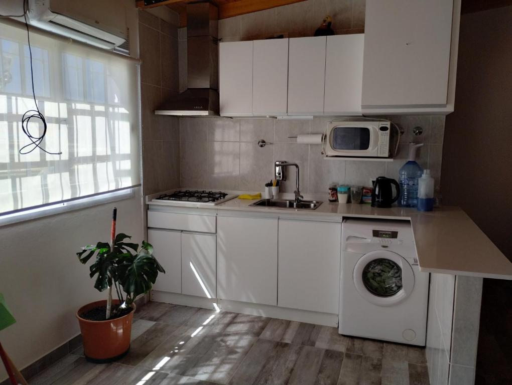 a kitchen with a washing machine and a microwave at LuMar3 in Comodoro Rivadavia