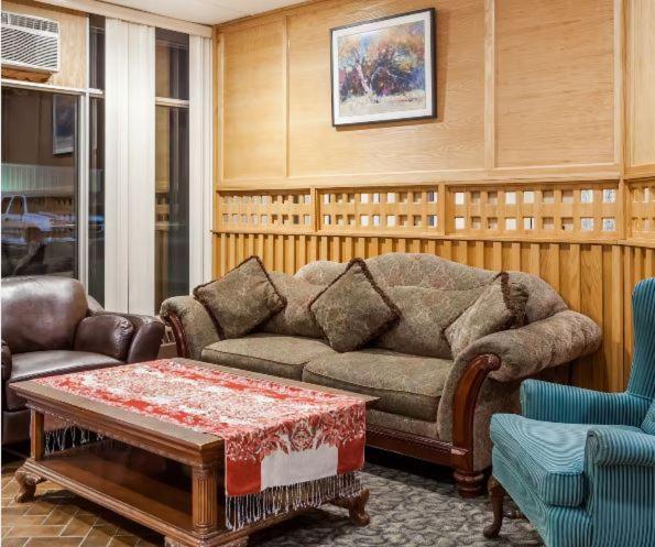 Melville的住宿－Best Stay Inn，客厅配有沙发和桌子