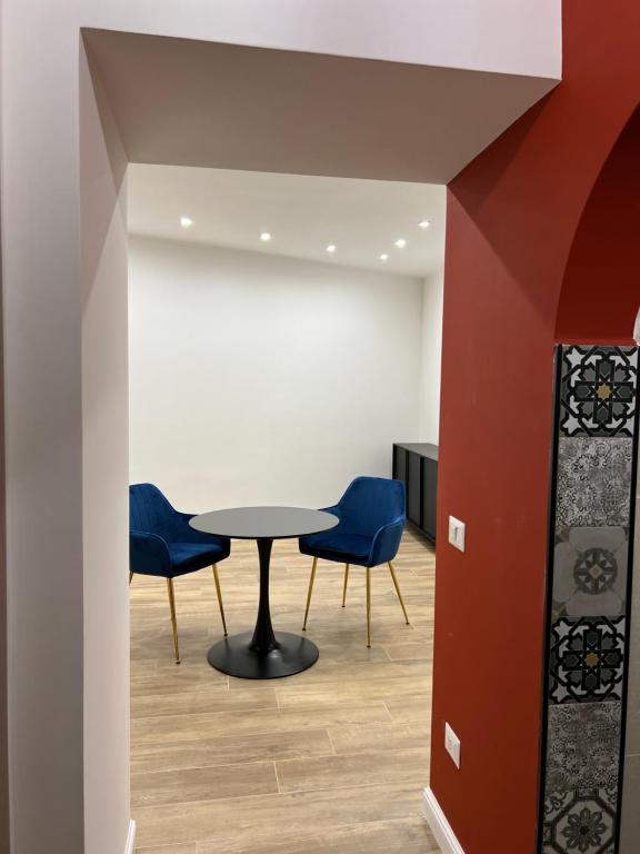 a meeting room with a table and blue chairs at Comfort La tombola tripla deluxe in Naples