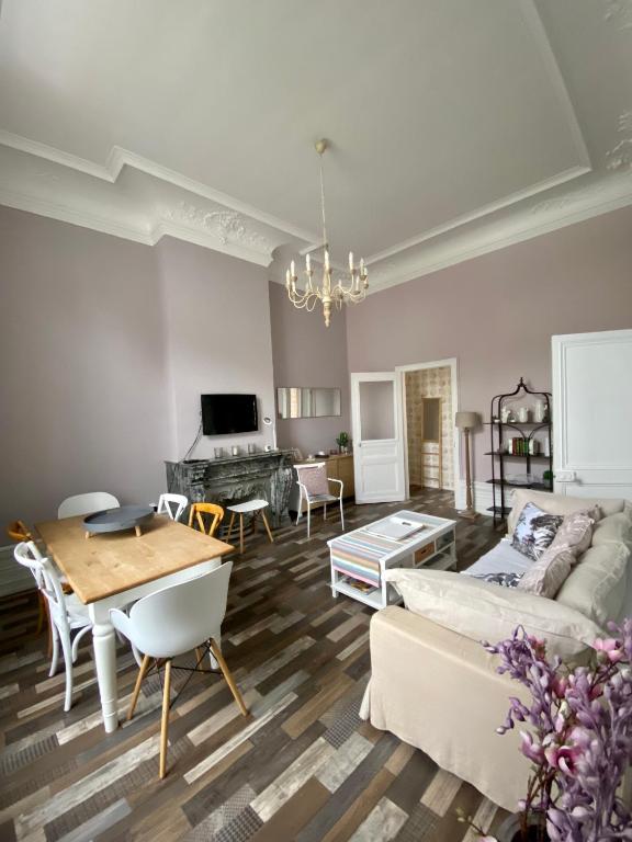 un salon avec un canapé et une table dans l'établissement GRAND APPARTEMENT DE STYLE HAUSSMANNIEN, à Boulogne-sur-Mer