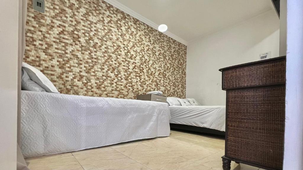 a bedroom with two beds and a brick wall at Casa Vera Cartagena in Cartagena de Indias