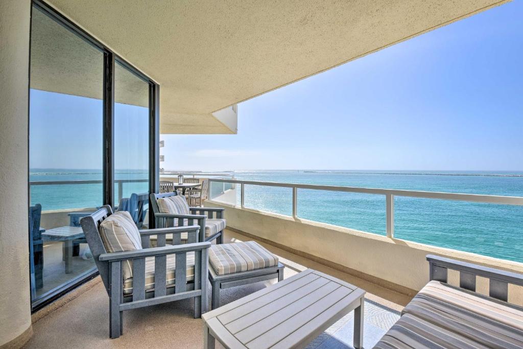 einen Balkon mit Stühlen, Tischen und Meerblick in der Unterkunft Gulf View Destin Condo with Resort Pool and Spa! in Destin