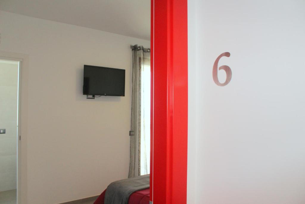 a room with a tv on the wall and a bed at Navicri B&B in Vieste
