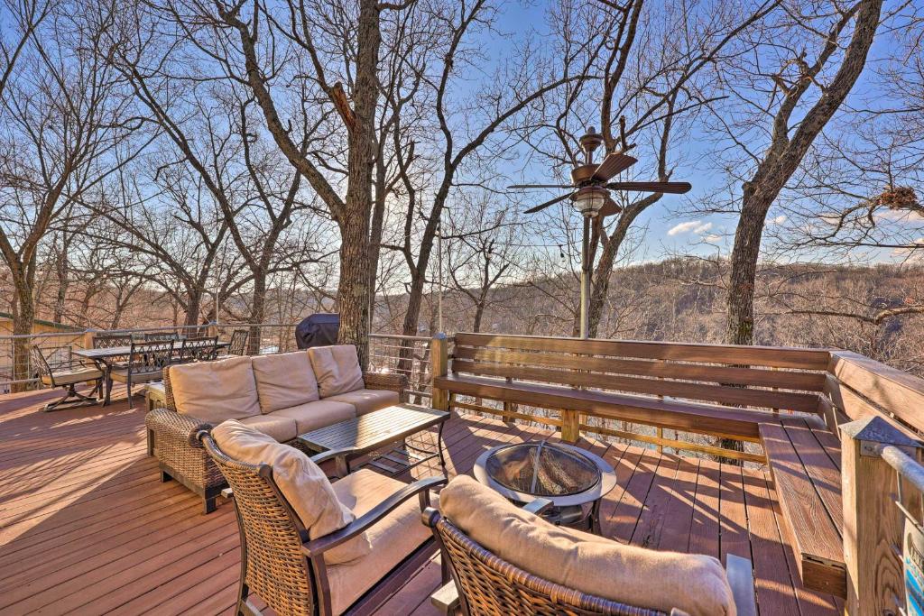 a wooden deck with a couch and a fire pit at Pet-Friendly Grand Lake House with Dock and Kayaks! in Eucha