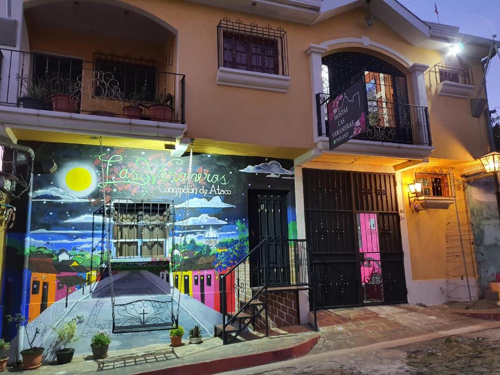 ein Gebäude mit einem Wandbild an der Seite in der Unterkunft Hostal Las Veraneras Ataco in Concepción de Ataco