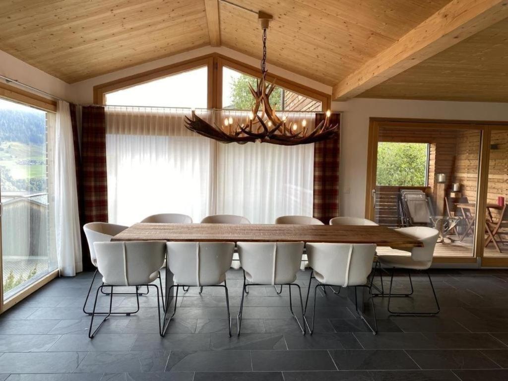 uma sala de jantar com uma grande mesa de madeira e cadeiras em Ferienhaus Lumnezia Lux em Cumbels