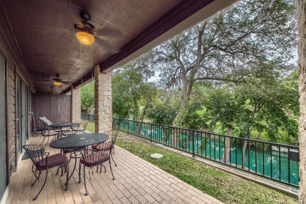 a patio with a table and chairs on a balcony at CW C109 River Bend in New Braunfels