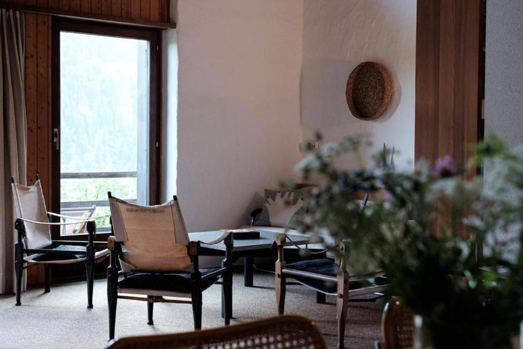 a room with chairs and a table and a window at La Stalla - Mid-Century Rustico in Calpiogna