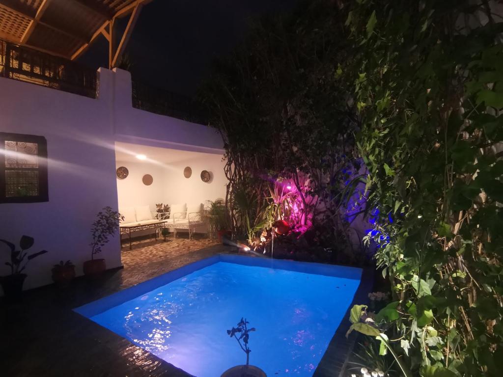- une piscine dans un jardin la nuit dans l'établissement Dar Ben Daoud avec piscine et terrasse privee, à Fès