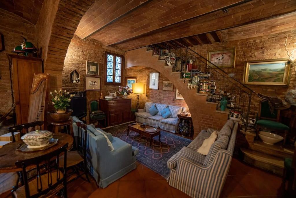 una sala de estar con una escalera en una casa en Casa Lazzaro al centro di Siena en Siena