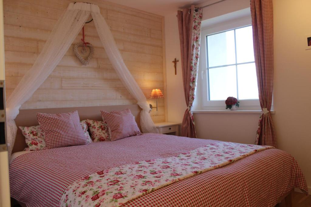 Schlafzimmer mit einem Bett und einem Fenster in der Unterkunft Haus Sonnbichel am Kochelsee in Schlehdorf