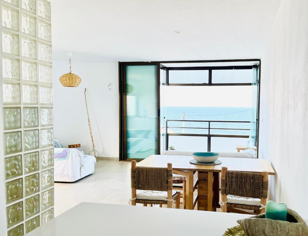 a dining room with a table and a view of the ocean at MiMar Jávea in Jávea