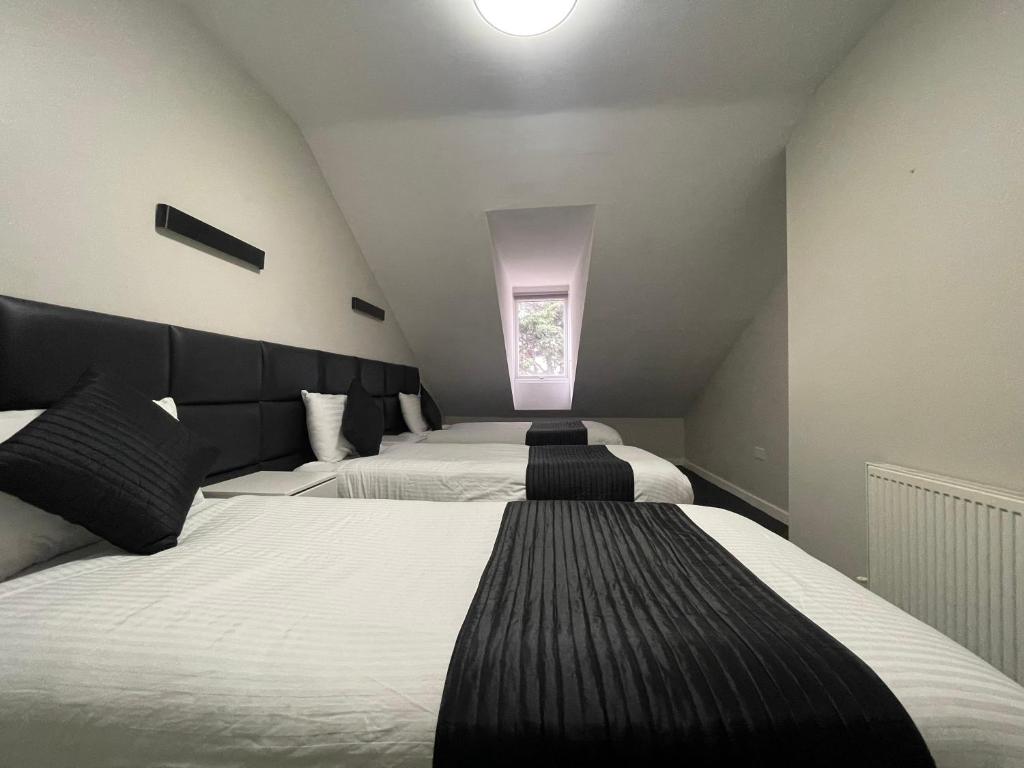 a bedroom with two beds and a window at Hosted By Ryan - 3 Bedroom Penthouse Apartment in Liverpool