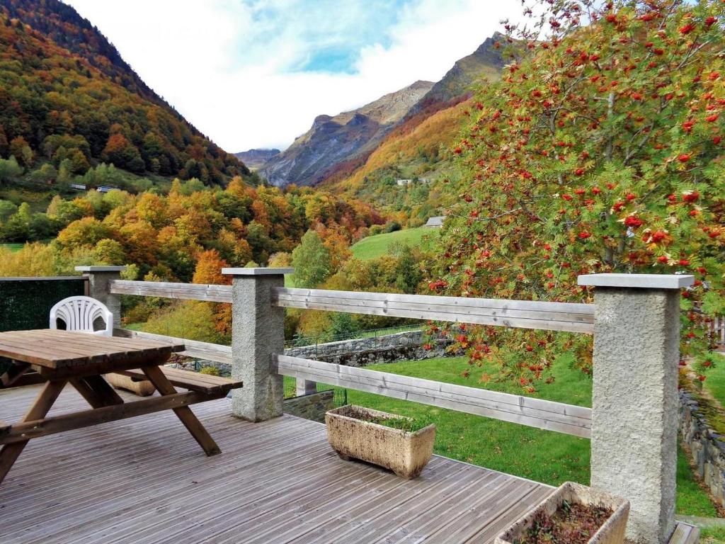 a wooden deck with a picnic table and a view of a mountain at Marmotte Gîte 2à4 personnes avec cheminée à 10mn des pistes in Aragnouet