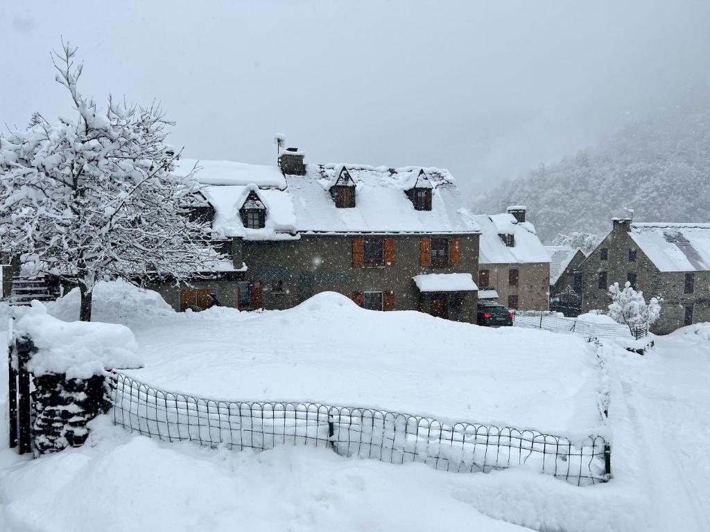 dom pokryty śniegiem z płotem w obiekcie Marmotte Gîte 2à4 personnes avec cheminée à 10mn des pistes w mieście Aragnouet