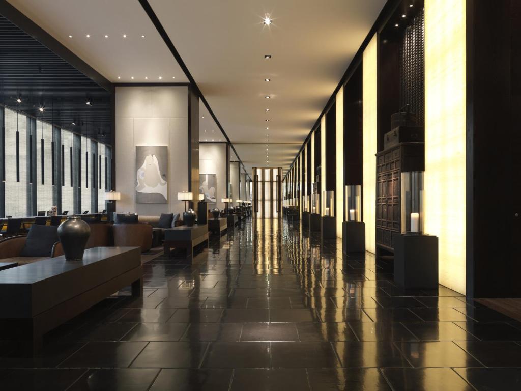 a lobby with a long hallway with couches and tables at The Puli Hotel And Spa in Shanghai