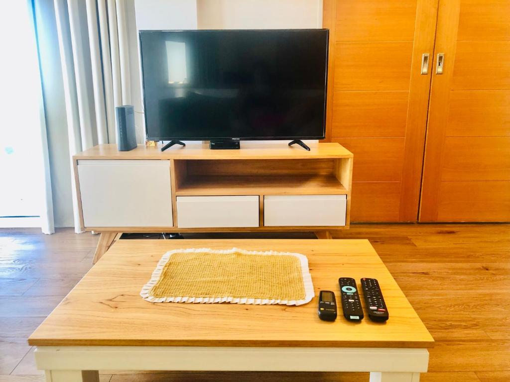 a living room with a tv and remote controls on a coffee table at Fantástico depto. con vistas panorámicas in Vicente López