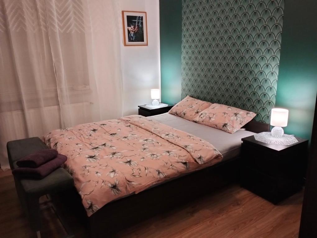 a bedroom with a bed with a pink comforter at Apartament w Centrum Cichy Zakątek in Gliwice